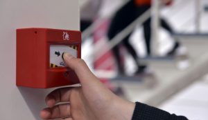 fire alarm installation hand pressing fire alarm