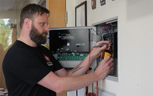 fire alarms service and maintenance man testing panel